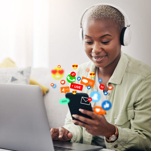 Laptop, social media icon or woman with phone for communication, message or online chat. Headphones, notification emojis or African person streaming music on mobile app on website or network at home.