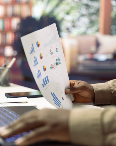 Freelancer developing a startup project and analyzing financial statistics from his home office, looking at accountancy papers. Professional analyst writing business reports, telecommuting.