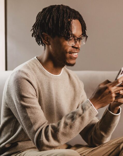 side-view-smiley-man-home-using-smartphone